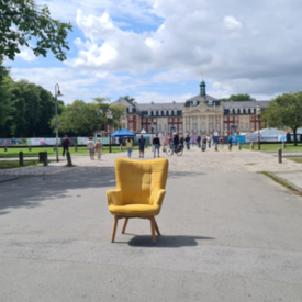 Gelber Stuhl steht vor einem Schloss.